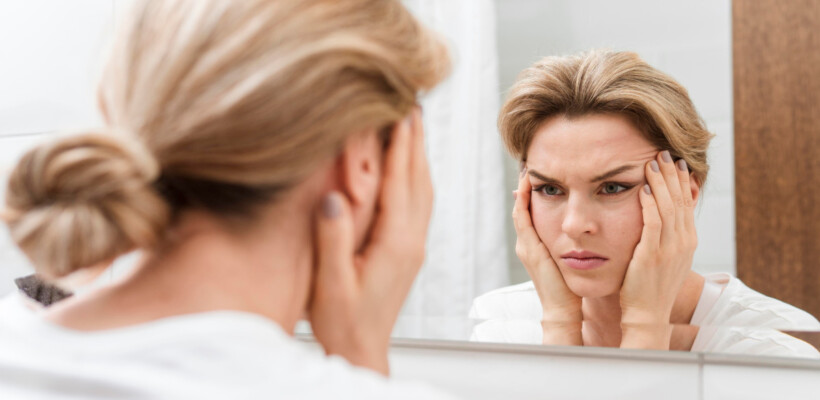 kobieta ogląda w lustrze swoje defekty ciała